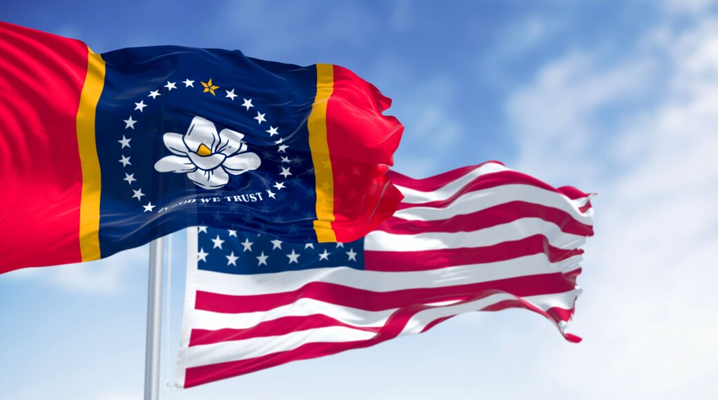 Mississippi state flag waving with the American flag on a clear day. Magnolia state. 3d illustration render. Rippling fabric. Selective focus