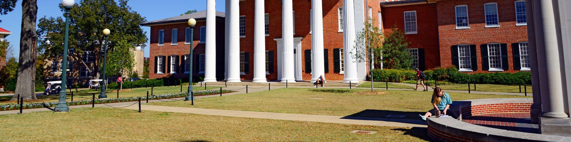 A large red brick building with white columns and a triangular pediment.