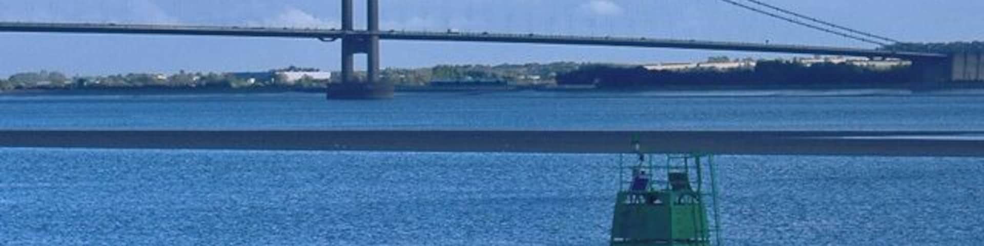 Humber buoy, from the shore east south east of North Ferriby, East Riding of Yorkshire, England. The little green boat I think must be an aid to shipping in the Humber, marking the deep water channel. In the background is the Humber Bridge (south tower). The same buoy is also pictured a year or so earlier at SE9921 : Channel Buoy 29 where it is on the opposite side of the Humber, showing presumably the degree of movement in the estuary's sandbanks.