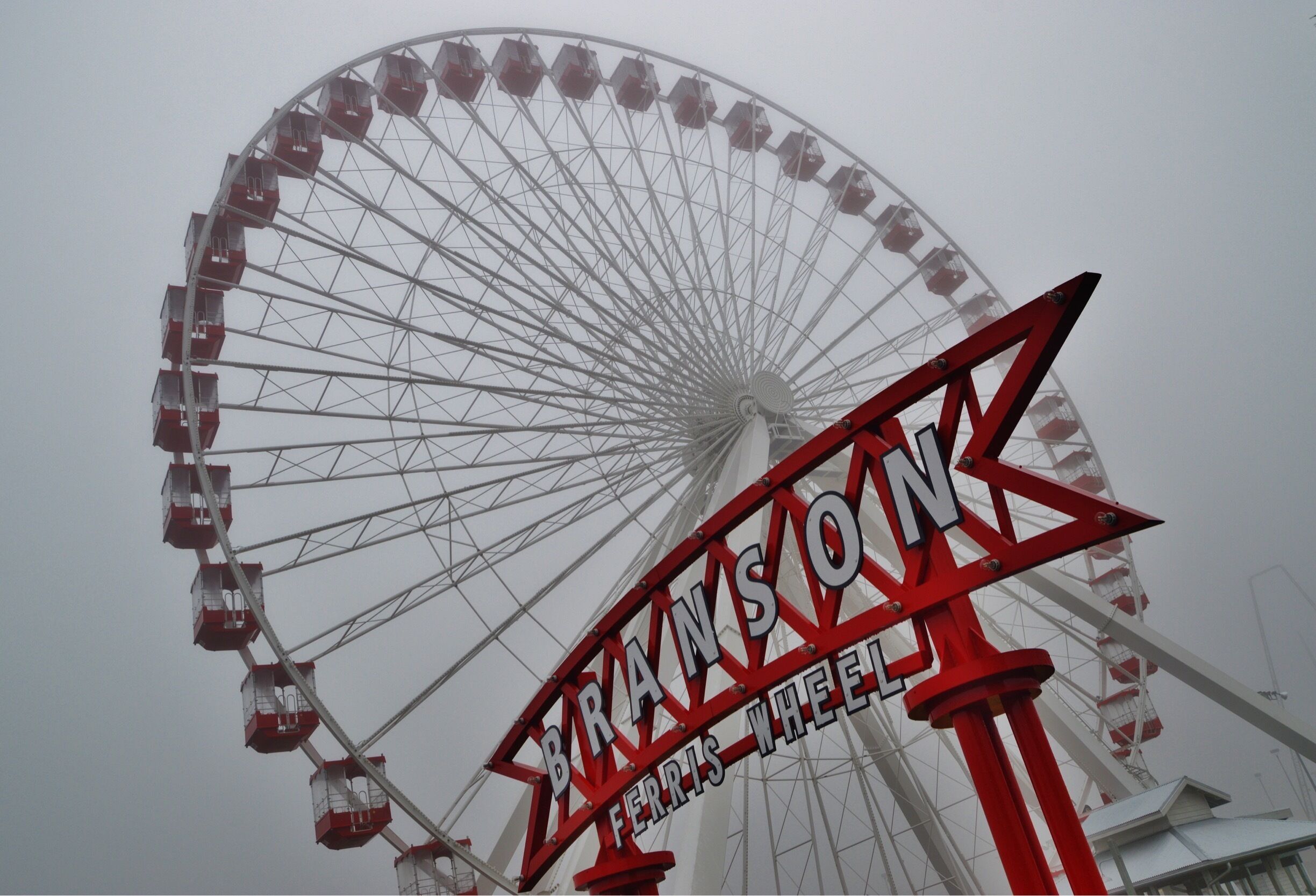 A Ferris wheel with cabins and a sign that reads "BRANSOLN FERRIS WHEEL".