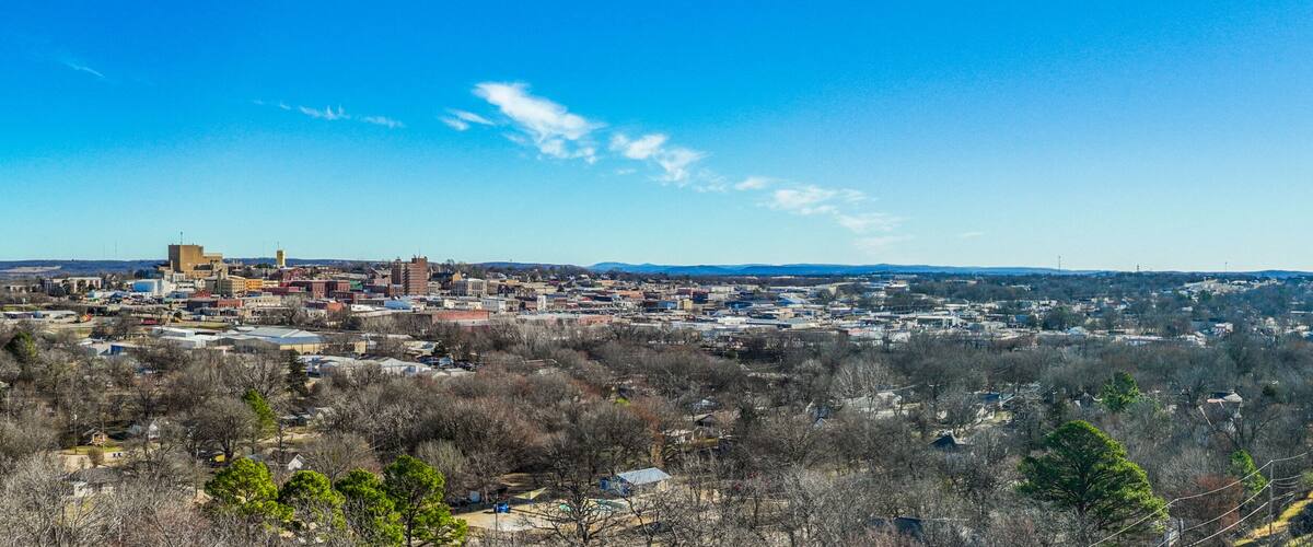 A town with a prominent church, a mix of residential and commercial buildings, and a hilly backdrop.