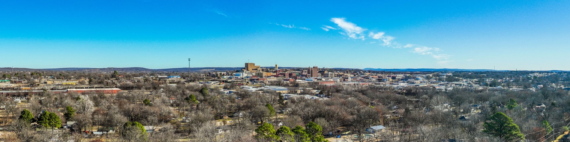 A town with a prominent church, a mix of residential and commercial buildings, and a hilly backdrop.