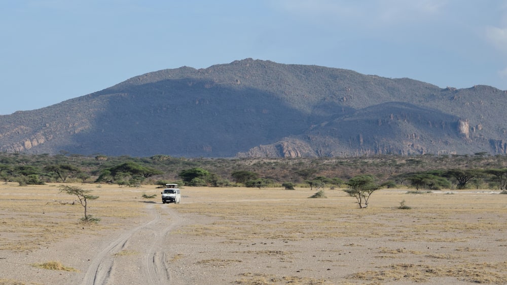 A tour van against a mountain background in the Shaba Game Reserve, Northern Kenya