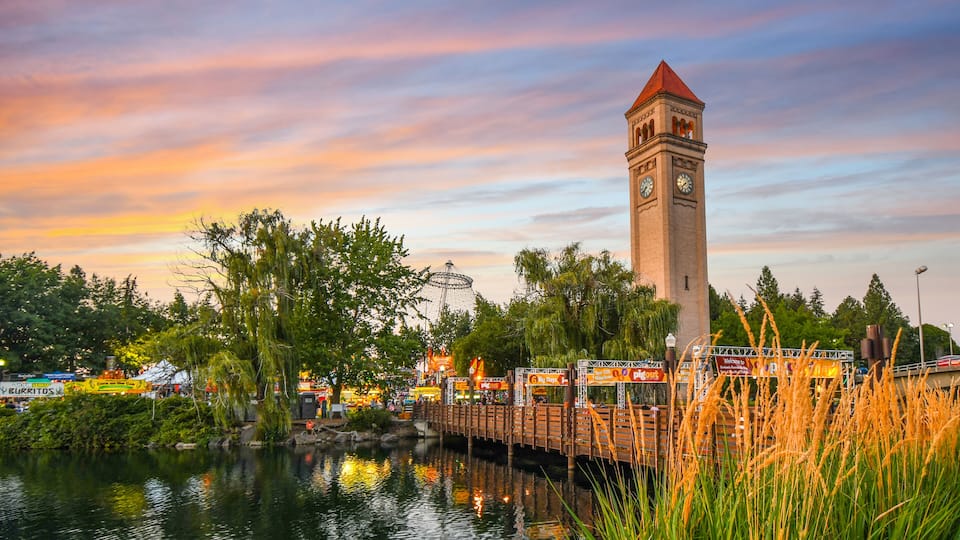 Festival goers enjoy a colorful sunset at the annual Pig out in the Park at Riverfront Park along the Spokane River in Spokane, Washington