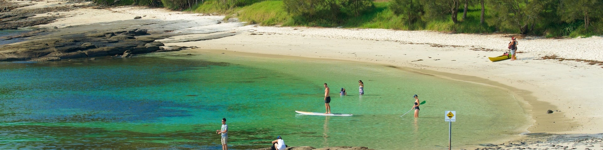 Huskisson featuring a sandy beach and general coastal views as well as a small group of people