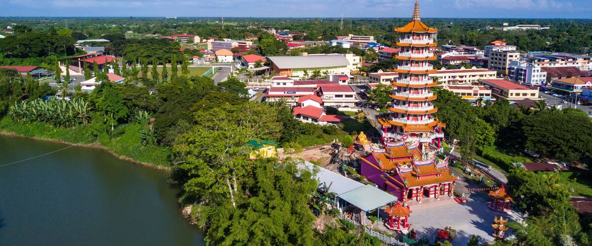 A pagoda with multiple tiers, surrounded by lush greenery and a body of water.