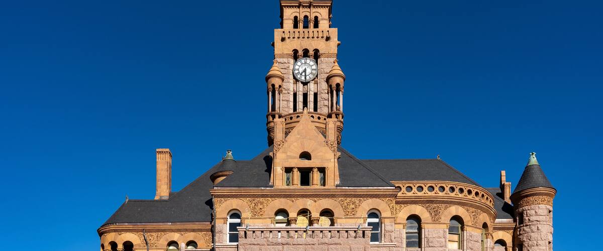 A historic building with a clock tower, arched windows, and a turret.