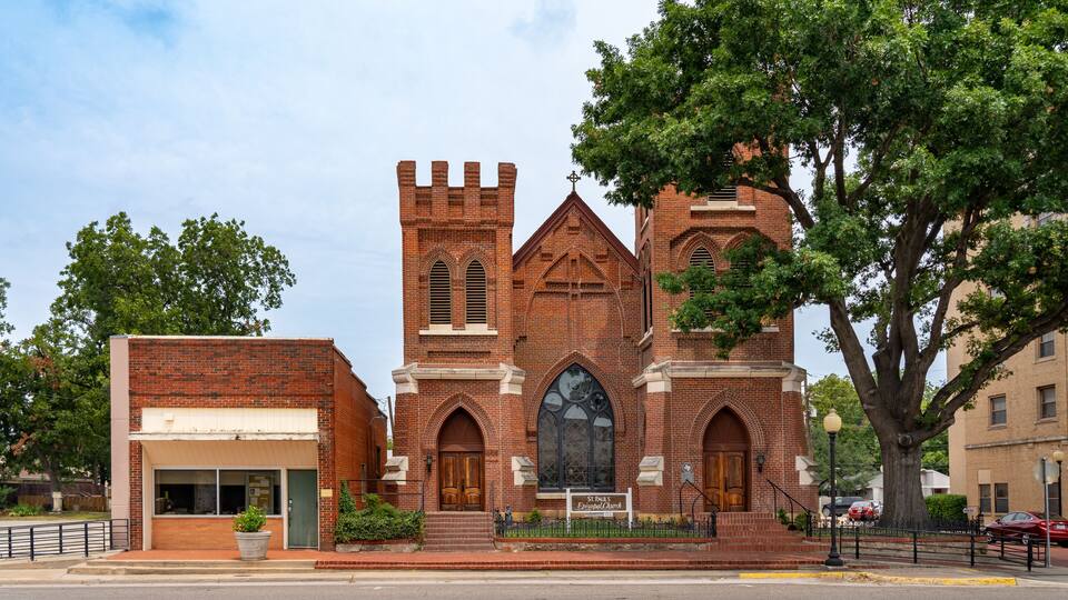 A historic brick church with a bell tower and arched windows.