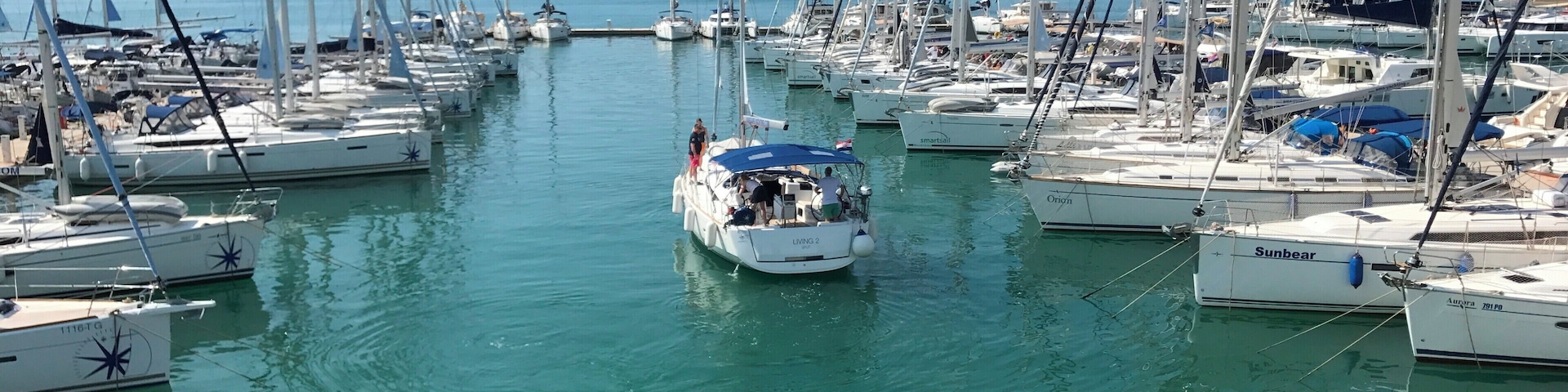 A marina with numerous sailboats docked in calm waters.