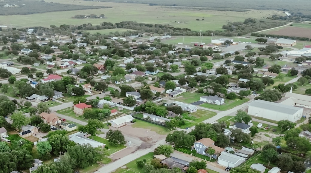 Panorama aerial view agriculture agro-town with residential houses, church buildings, small local business surrounding by large farmland ranch in Three Rivers, Texas, suburban rural, small town