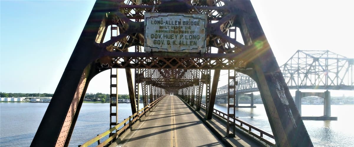 A bridge with a sign reading "LONG-ALLEN BRIDGE BUILT UNDER THE ADMINISTRATION OF GOV. HUEY P. LONG GOV. S. K. ALLEN".
