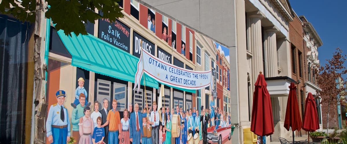 A mural on a building depicting a group of people in various outfits, with a banner reading "Ottawa Hula Hoop Champs" and "Ottawa Celebrates the 1950s."