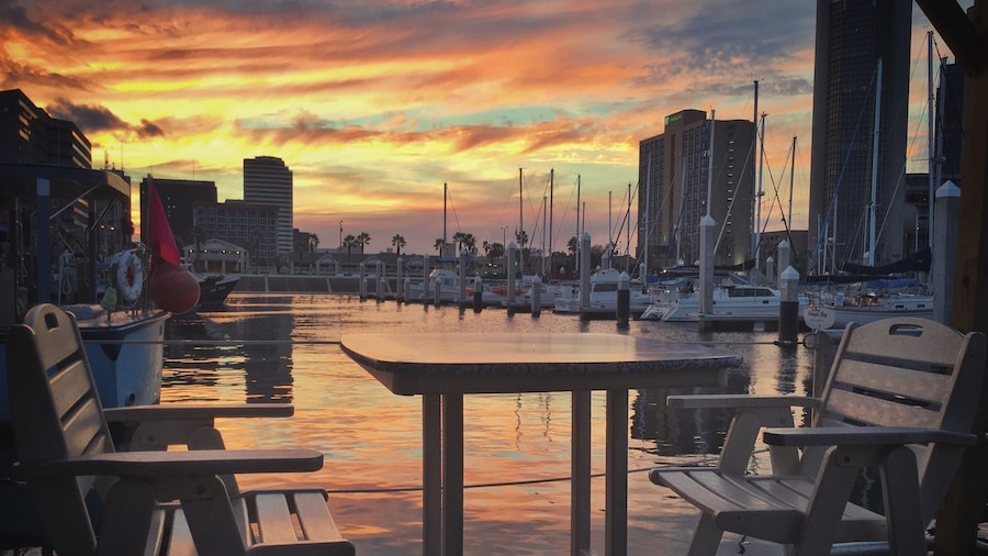 On a work-road trip to McAllen, Texas I had the opportunity to swing by Corpus Christi and grab dinner. No parading, no shopping planned, just a quick bite before seeing more freeway. I wasn't expecting to see very much.
Boy, was I surprised. We stopped for dinner just 4 miles off our route at Harrison's in Corpus Christi. We sat in the "floating" seating, a roped off dock with tables and chairs, and enjoyed some of the town's talented musicians singing homegrown versions of Sublime songs. The sun set with beautiful yellow and orange colored clouds reflected in the water and I was amazed no others were photographing this beautiful scene. Maybe indifferent, or maybe used to the beauty that is this town, and us the tourists making ourselves clearly known.
Thank you Corpus Christi for your beauty and your meal. I'm sorry our stay was rushed, we will definitely be back!