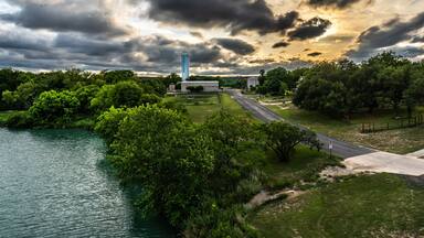 Un río, árboles verdes, una carretera y una torre alta.