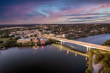 A river with a bridge, a town, and a large building with a dome.