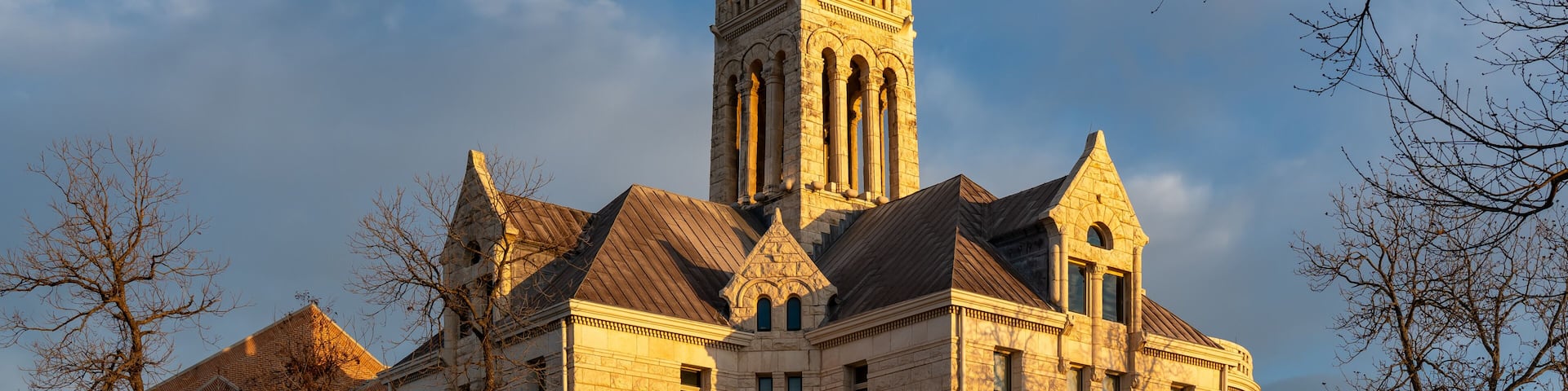 A historic building with a prominent tower and arched windows.