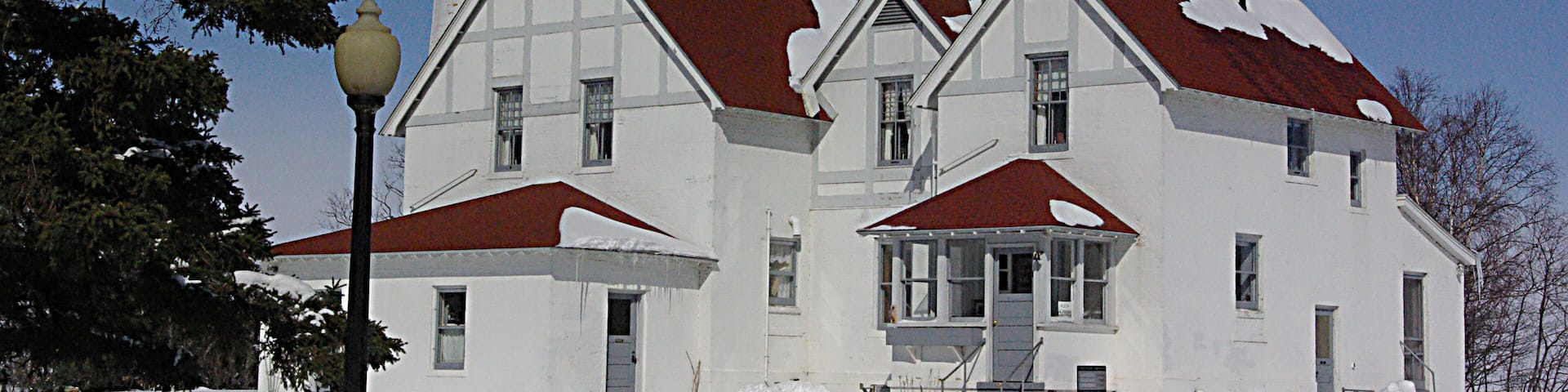 A white building with a red roof and a tower.