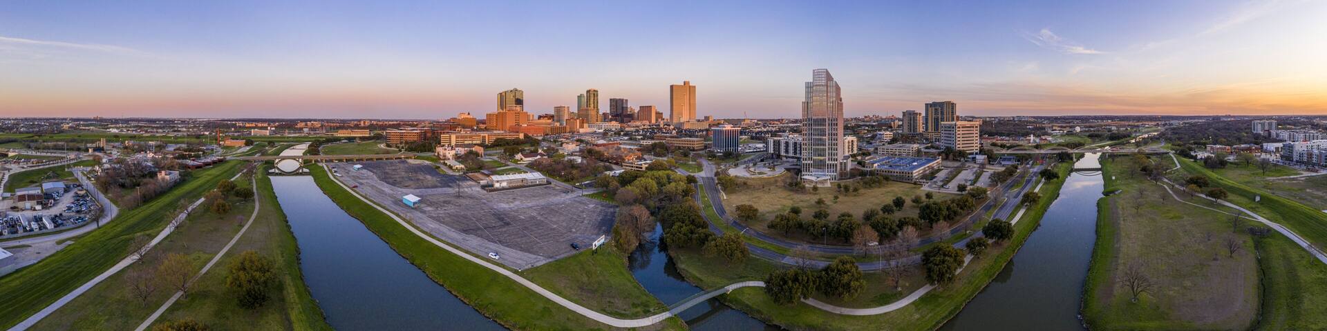 Aerial panorama picture of the Fort Worth skyline at sunset from west direction with sun reflections