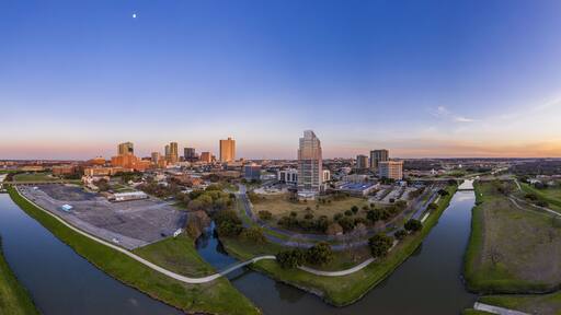 Aerial panorama picture of the Fort Worth skyline at sunset from west direction with sun reflections