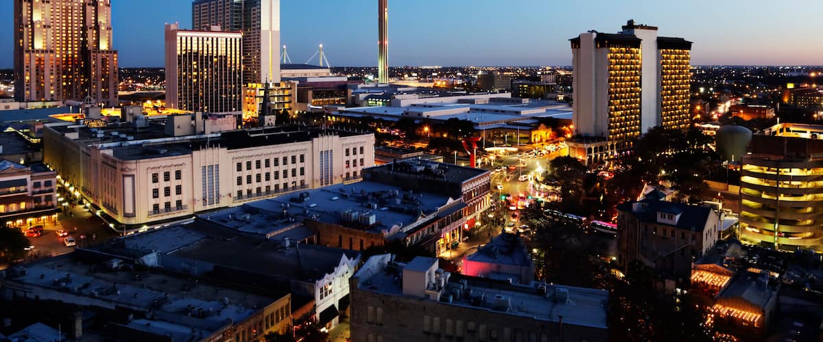 A cityscape with a prominent tower, several high-rise buildings, and a mix of older and modern architecture.