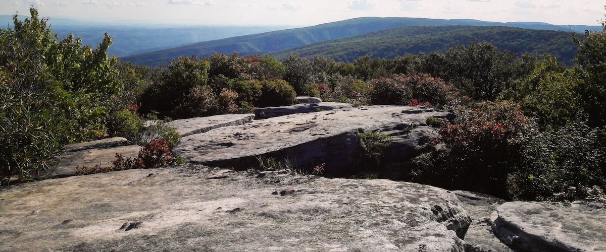 A mountainous landscape with rocky outcrops and dense greenery.