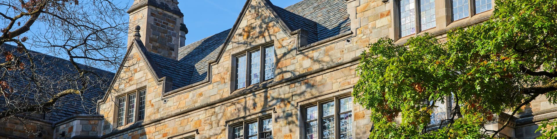 A historic stone building with multiple windows and a prominent chimney.