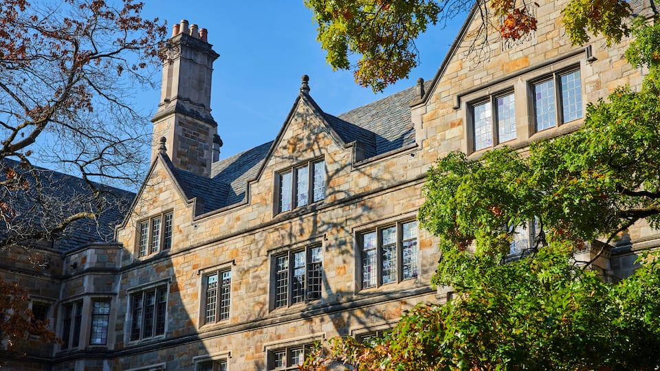 A historic stone building with multiple windows and a prominent chimney.