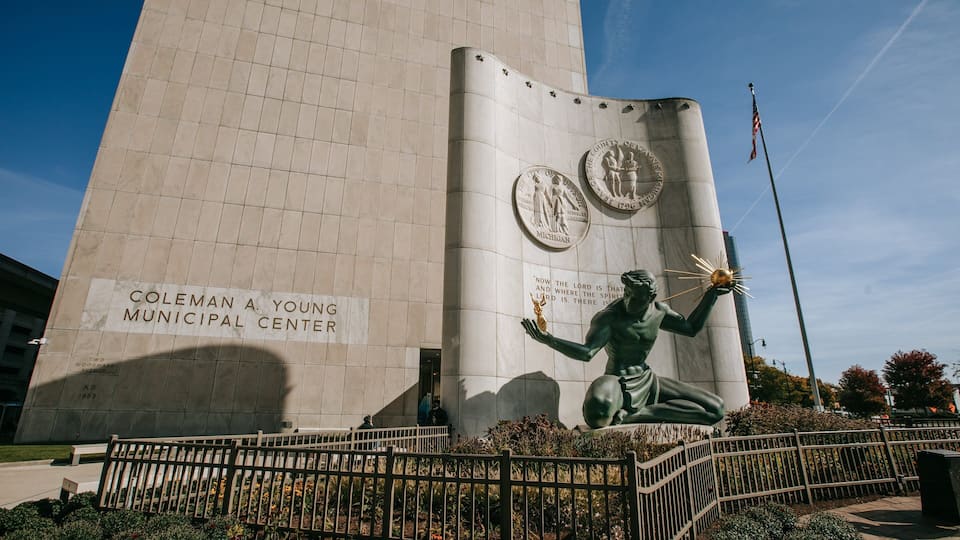 Het Coleman A. Young gemeentehuis met een standbeeld van een figuur die een fakkel vasthoudt.