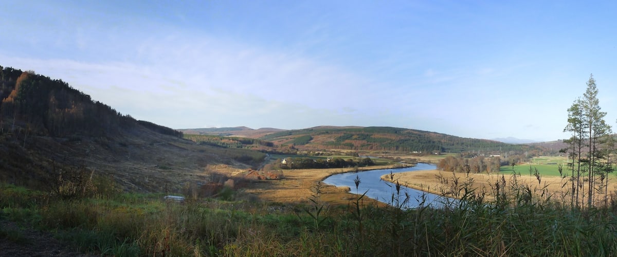 A river winding through a valley with hills on either side.