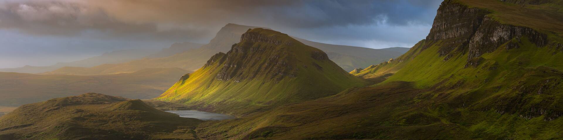 Dramatic mountains of the Isle of Skye seen from viewpoint on the Quiraing. Large panorama with dark moody clouds. Scotland landscapes, Inner Hebrides, UK.