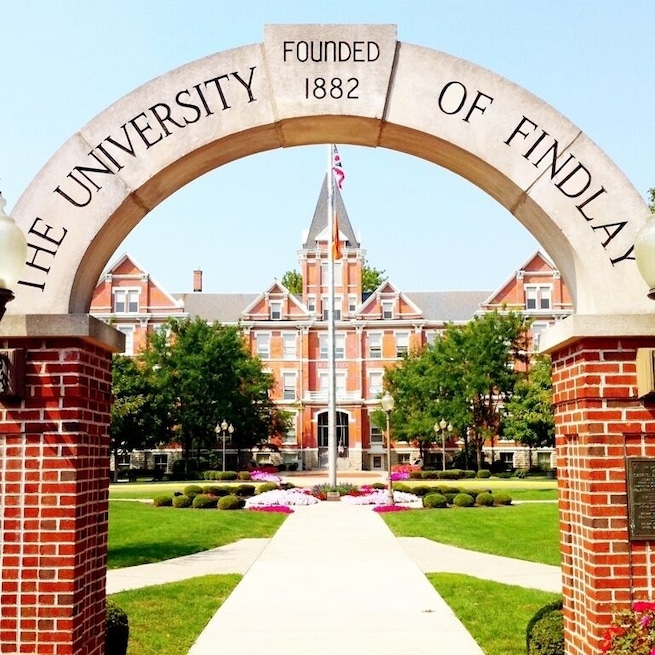 Un arco con la inscripción "The University of Findlay Founded 1882" que da acceso a un edificio.