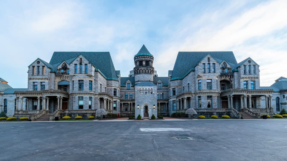 A large, historic stone building with multiple towers and a central turret.