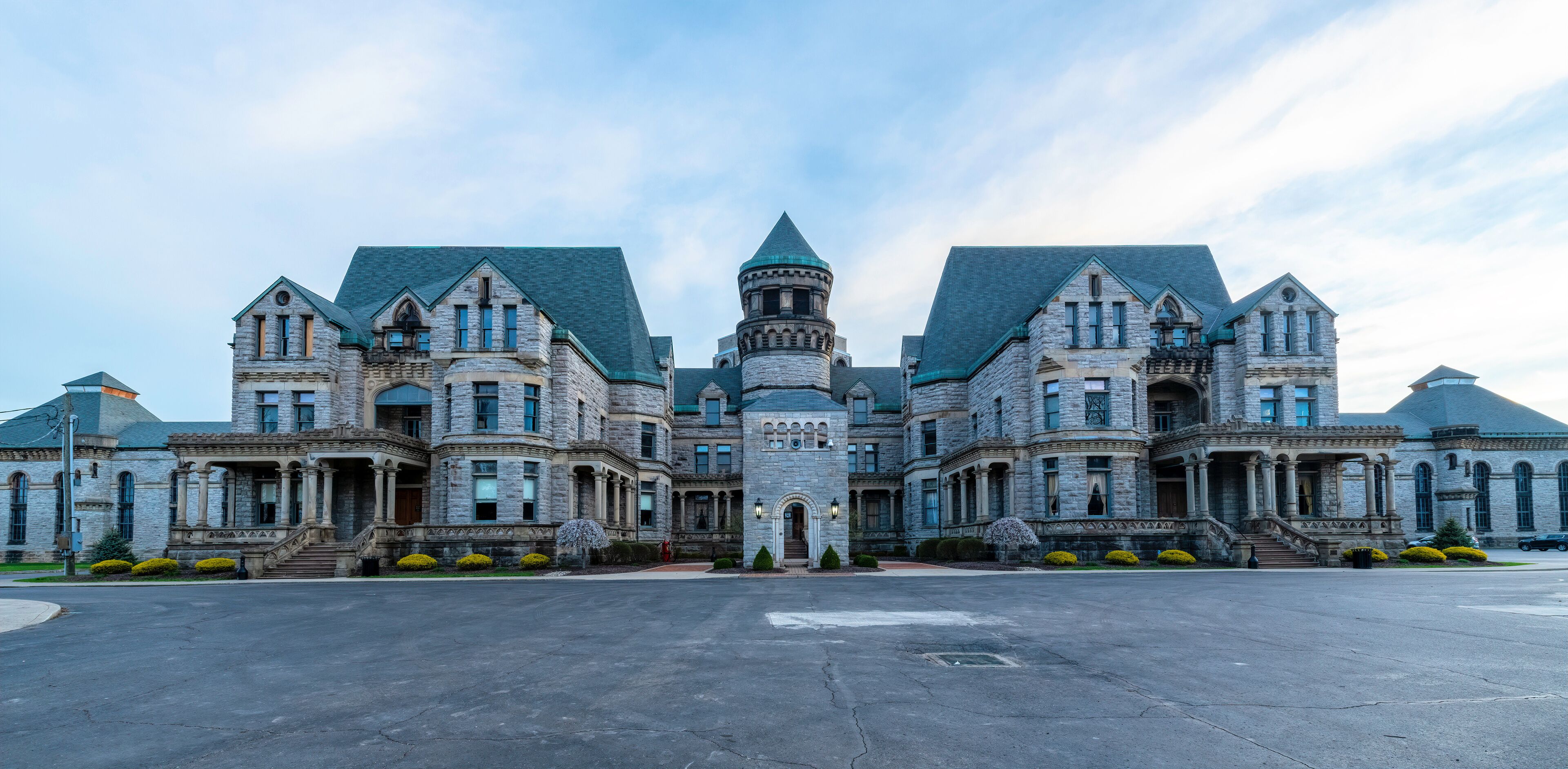 A large, historic stone building with multiple towers and a central turret.