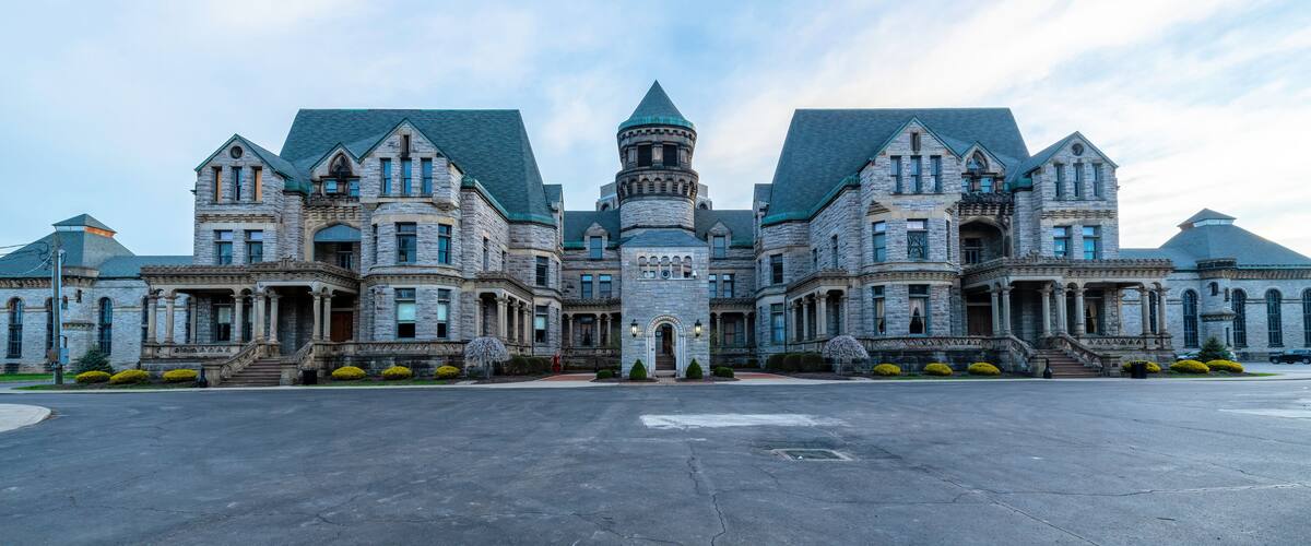 A large, historic stone building with multiple towers and a central turret.