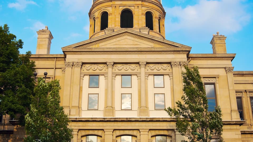 A classical building with a dome, arched windows, and a clock tower.