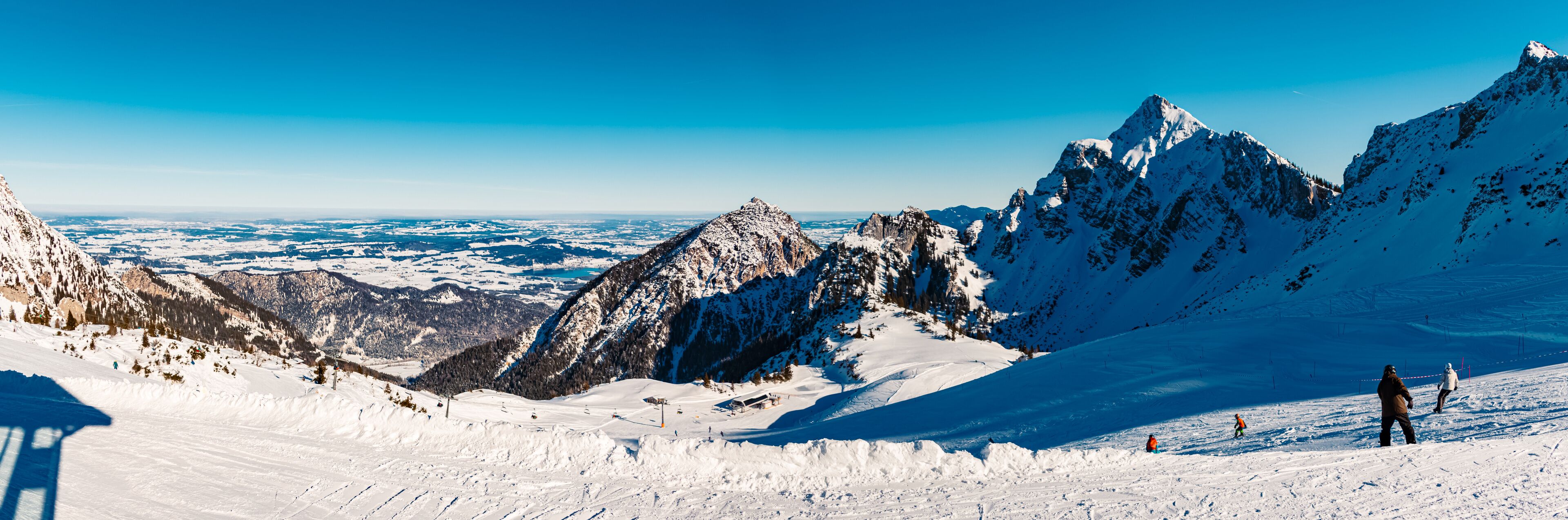 A snow-covered mountain landscape with ski slopes and a ski lift.
