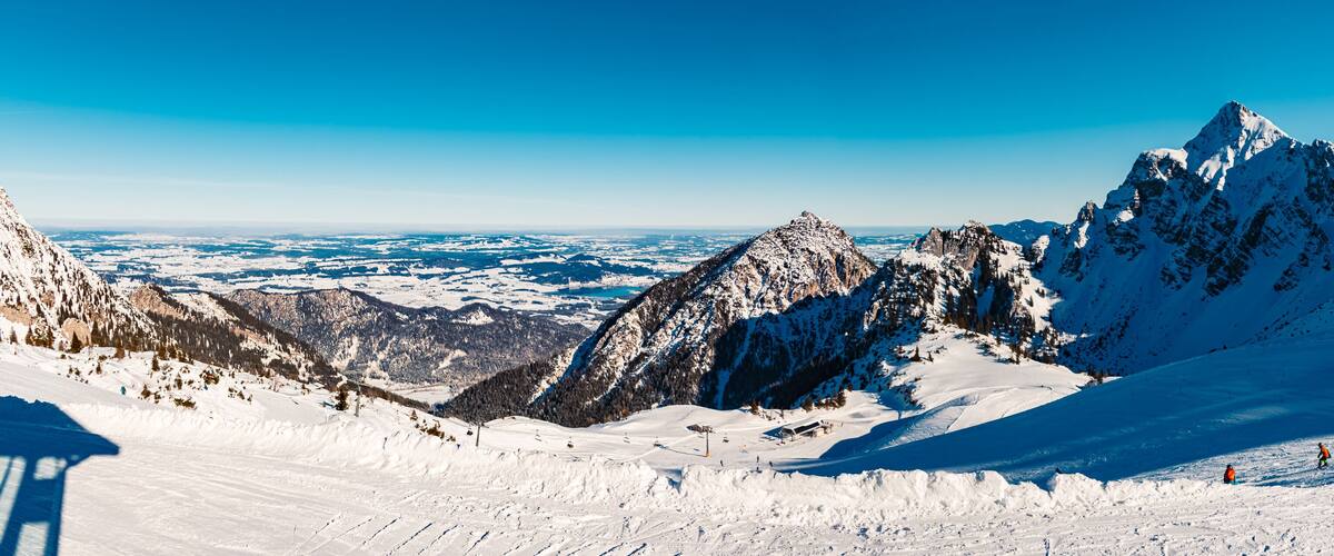 A snow-covered mountain landscape with ski slopes and a ski lift.