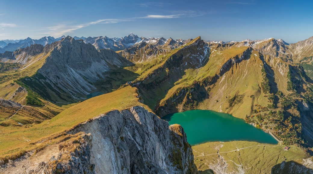 Une chaßne de montagnes avec un lac niché dans une vallée.