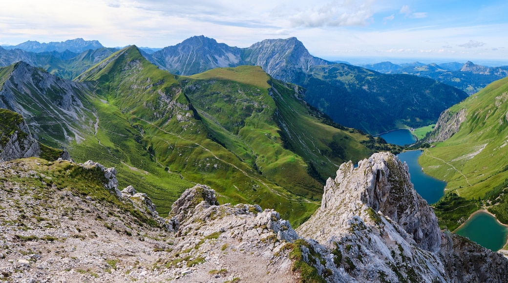 Un paysage montagneux avec une vallée, un lac et des sommets lointains.