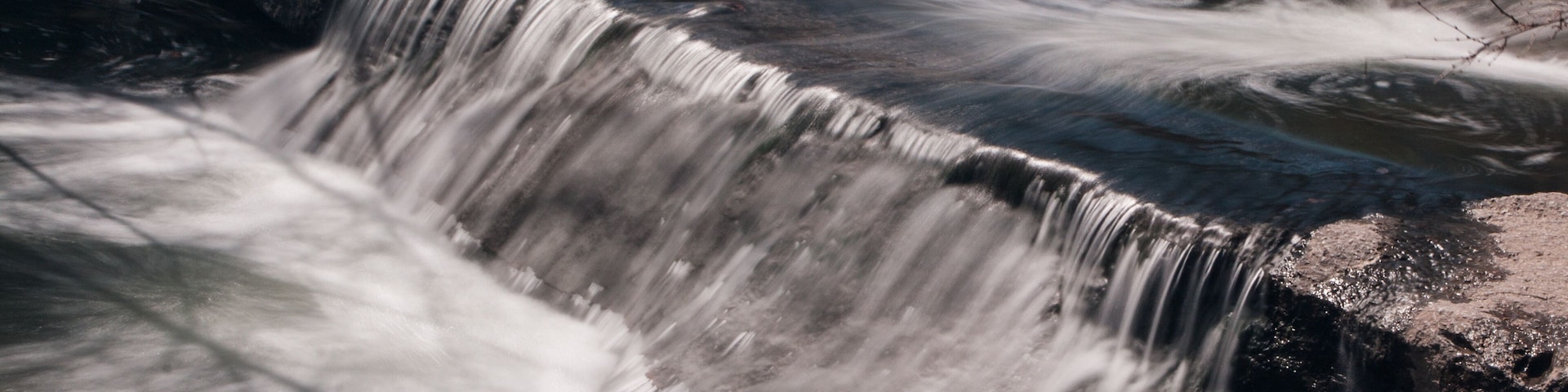 Una cascada que se precipita sobre un saliente rocoso.