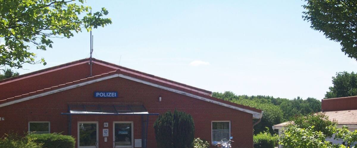 A red brick police station with a motorcycle parked in front.