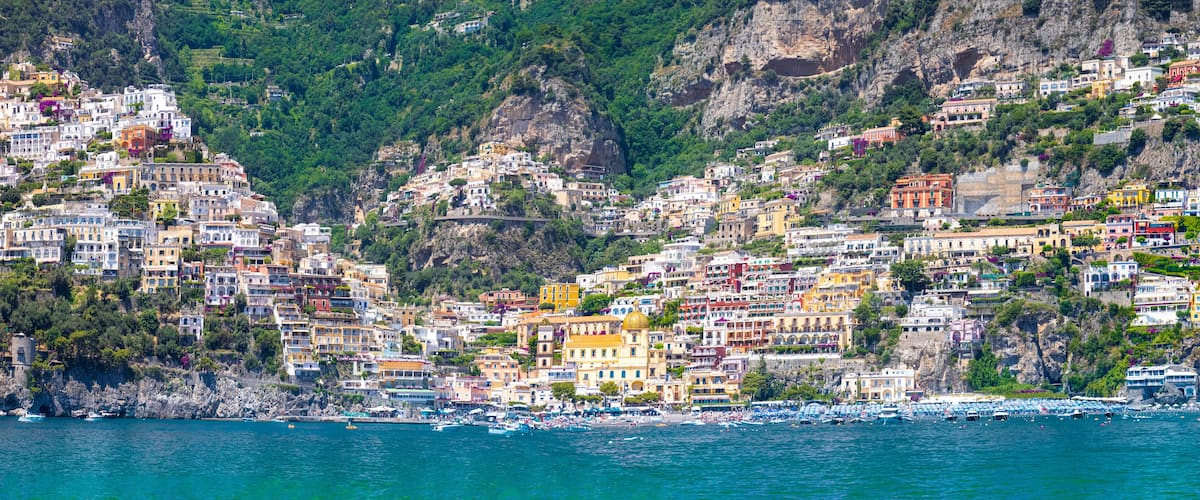 A coastal town with colorful buildings perched on a hillside overlooking the sea.