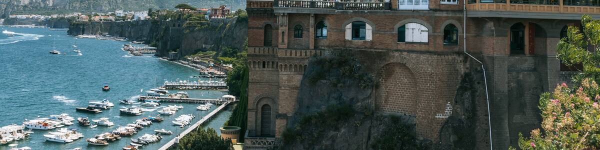 Une ville côtière dotée d’un port de plaisance, de bâtiments historiques et bordée de montagnes.