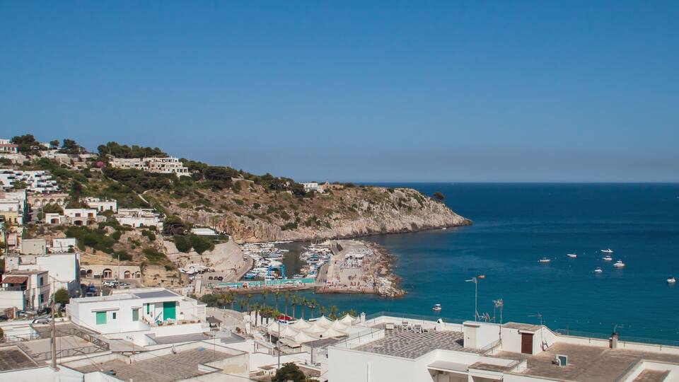 A coastal town with buildings on a hillside overlooking the sea.