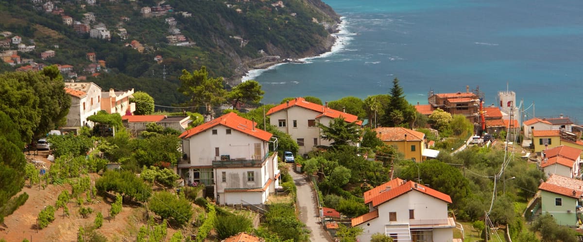 Un pueblo costero con casas escalonadas y una ladera empinada.