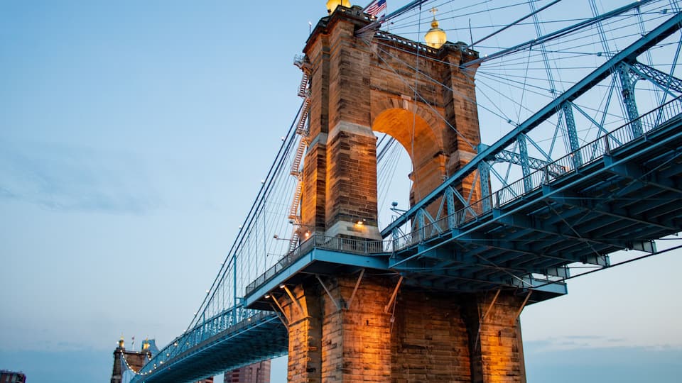 A large stone bridge with a blue metal arch and a golden dome.