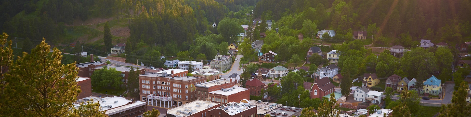 A town nestled in a valley with a river running through it, surrounded by hills.