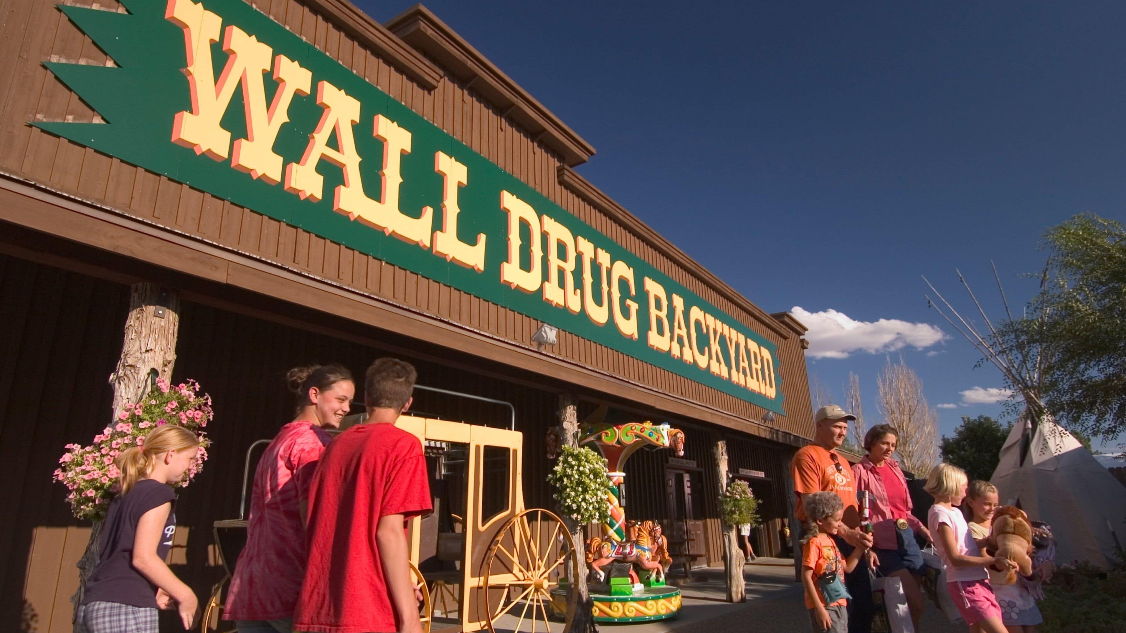 Un edificio con un letrero que dice "WALL DRUG BACKYARD".