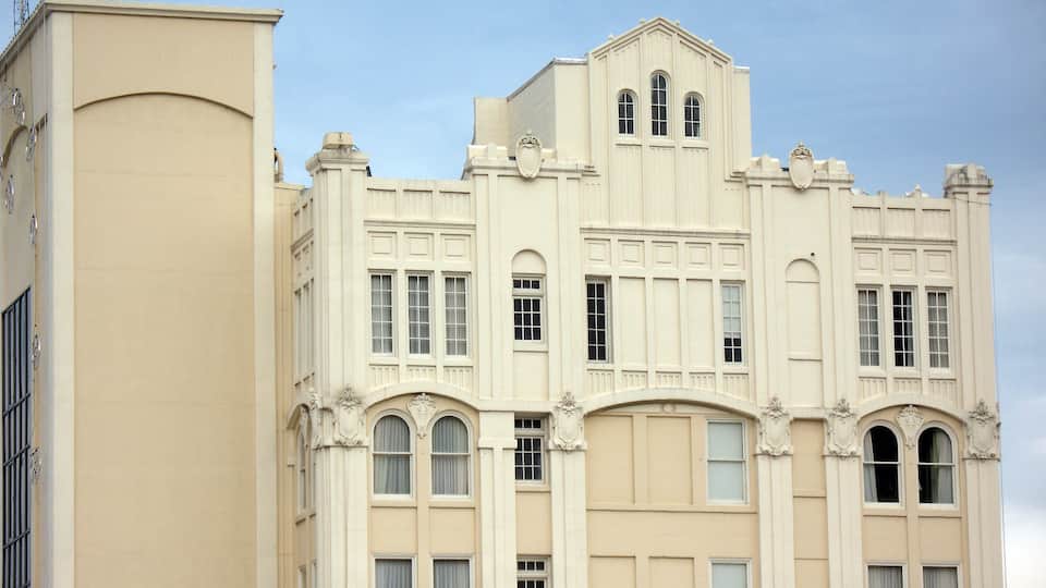 A large, cream-colored building with ornate architectural details, including arched windows and decorative moldings.