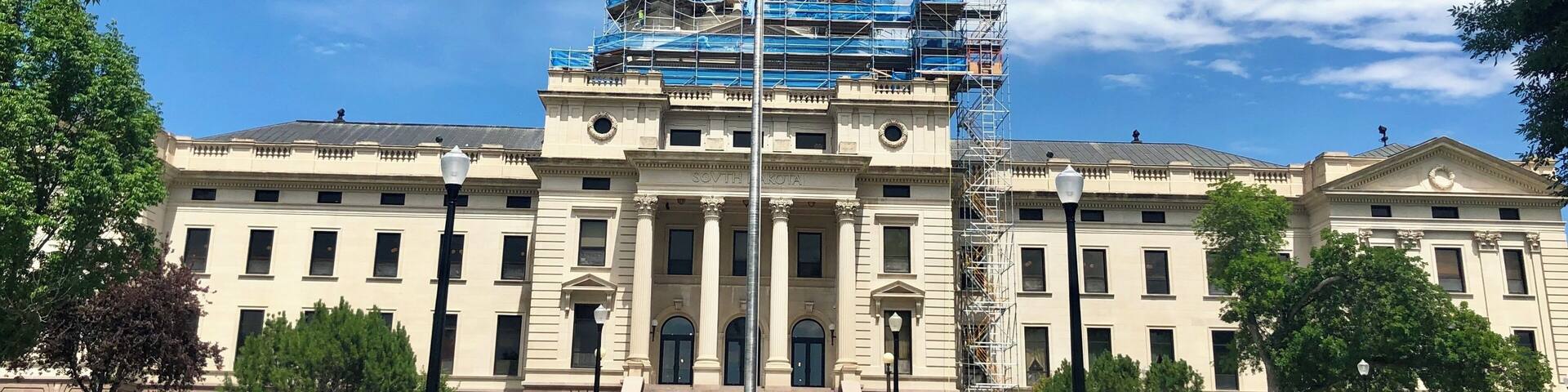 A large government building with a dome and scaffolding.